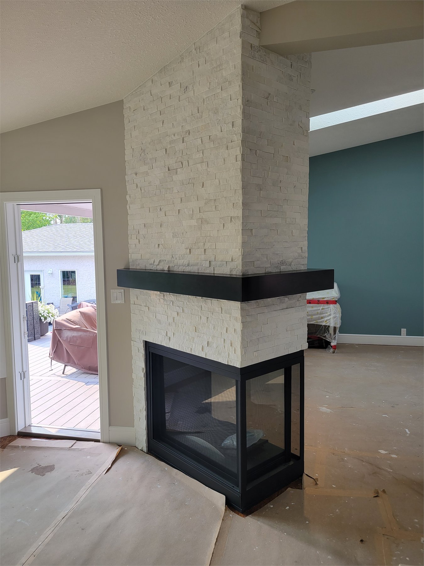 Travertine ledge stone fireplace with mitered corners and an angled ceiling, detail view 2